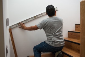 Instalador tomando medidas y marcando para instalar pasamanos