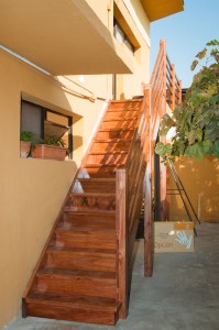 Escalera recta de pino teñido con baranda lateral